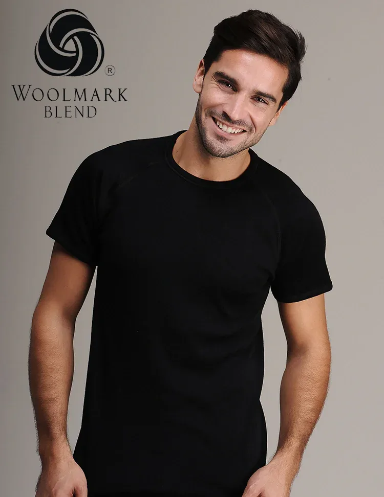 4015%20-%20Men%27s%20Black%20Raglan%20Short%20Wool%20Sleeve%20-%204015 Woolmark Blend logo with a smiling man in black t-shirt, casual portrait, modern fashion, neutral background, emphasizing style and comfort.
