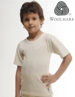 Cream-colored children’s t-shirt made from Woolmark certified fabric, featuring a small embroidered cartoon bear on the bottom left, perfect for casual wear and comfortable for kids.