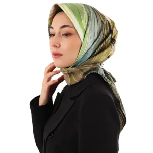 Elegant woman wearing a stylish, colorful silk scarf with shades of green, beige, and black, paired with a black blazer for a sophisticated look, showcasing Turkish fashion products.