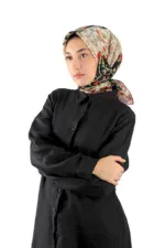 Elegant woman wearing a floral silk headscarf and black button-up shirt, showcasing Turkish fashion and traditional accessories, perfect for a stylish and cultural look.