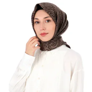 Sophisticated brown patterned silk hijab styled on a woman with a white blouse, perfect for elegant everyday wear or special occasions.