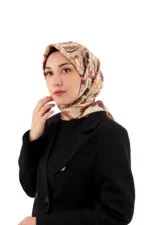 Elegant woman wearing a stylish floral patterned silk hijab and a black blazer, showcasing modest fashion for versatile and chic everyday wear. Ideal for women embracing cultural style with modern elegance.