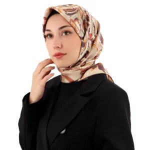 Elegant woman wearing a stylish floral patterned silk hijab and a black blazer, showcasing modest fashion for versatile and chic everyday wear. Ideal for women embracing cultural style with modern elegance.