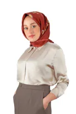 Elegant woman wearing a silky beige blouse and taupe high-waisted trousers, accessorized with a stylish floral-patterned satin silk hijab, showcasing modest fashion and Turkish style.