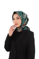 Vibrant patterned silk hijab in shades of teal, white, and orange worn by a woman in a black blazer, symbolizing elegance and cultural fashion with a focus on high-quality Turkish textile craftsmanship.