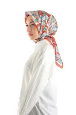 Vibrant floral patterned silk scarf wrapped around a woman's head, showcasing elegant Turkish fashion accessories from Turkey.