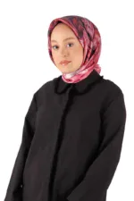 Silk pink and black patterned headscarf worn by a woman with fair skin and blue eyes, styled with a black jacket against a plain white background.