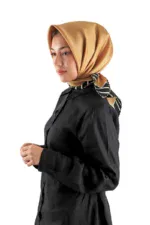Elegant woman wearing a luxurious gold satin hijab with stylish black blouse, showcasing Turkish fashion and accessories available for purchase with fast shipping from Turkey.