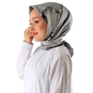 Luxurious silver satin hijab styled on a woman with a white blouse, showcasing elegant modest fashion accessories from Turkey, perfect for stylish, cultural, and modern looks.