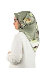 Beautiful woman wearing a stylish floral patterned hijab in shades of green, beige, and brown, with a white outfit, highlighting elegant fashion and modest dressing from Turkey.