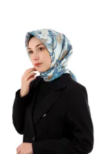 Elegant woman wearing a Turkish silk scarf with intricate blue and orange patterns, dressed in a black blazer, showcasing traditional Turkish accessories for fashion and cultural appreciation.