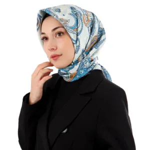Elegant woman wearing a Turkish silk scarf with intricate blue and orange patterns, dressed in a black blazer, showcasing traditional Turkish accessories for fashion and cultural appreciation.