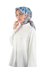 Elegant woman wearing a colorful floral patterned silk scarf and a white pleated long-sleeve blouse, showcasing stylish Turkish fashion accessories available at Shop of Turkey for fast shipping worldwide.