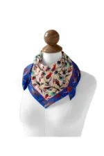 Vivid silk scarf with Turkish floral and animal motifs, brightly colored on a cream and blue background, displayed on a mannequin head.