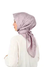 Luxurious pink paisley patterned silk satin hijab draped on a woman in a white blouse, showcasing elegant modest fashion suitable for special occasions or everyday wear.