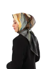 Elegant woman wearing a colorful silk headscarf with abstract patterns, styled with a black blazer for a sophisticated look, showcasing Turkish fashion accessories and craftsmanship.
