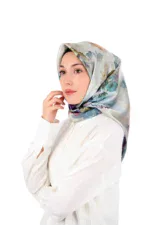 Elegant woman wearing a silk floral hijab and white blouse, showcasing stylish modest fashion with fast shipping from Turkey. Perfect for those seeking quality Turkish accessories.
