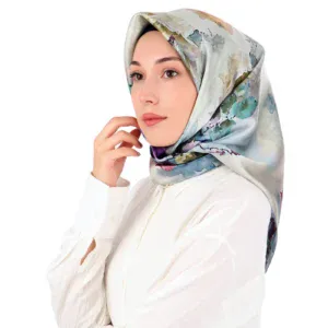 Elegant woman wearing a silk floral hijab and white blouse, showcasing stylish modest fashion with fast shipping from Turkey. Perfect for those seeking quality Turkish accessories.
