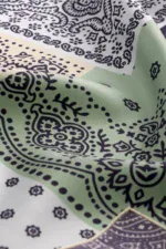 Vintage Turkish bandana with traditional black paisley and floral patterns on pastel green and white background, perfect for stylish accessories and cultural fashion statements.