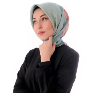 Elegant woman wearing a pastel-colored silk hijab and black clothing, showcasing stylish modest fashion from Turkey. Perfect for modern, sophisticated look with high-quality Turkish textiles.