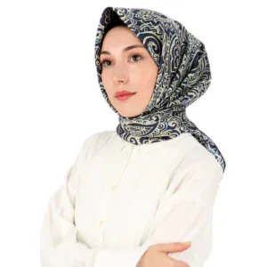 Elegant woman wearing a stylish navy blue and gold patterned silk headscarf, showcasing the popular Turkish hijab fashion, perfect for sophisticated and modest outfits worldwide.