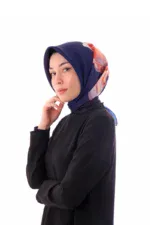 Elegant woman wearing a stylish navy blue hijab with a colorful floral accent, dressed in a black top, showcasing modest fashion with a modern touch.