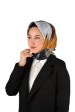 Elegant woman wearing a colorful silk silk hijab and formal black blazer, showcasing stylish modest fashion for professional and cultural wear.
