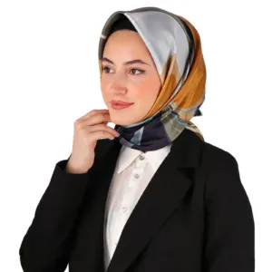 Elegant woman wearing a colorful silk silk hijab and formal black blazer, showcasing stylish modest fashion for professional and cultural wear.
