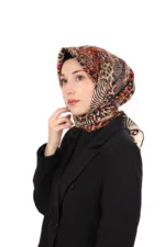 Vibrant animal print silk scarf styled as a hijab on a woman with natural makeup and black blazer. Perfect for elegant modest fashion and versatile style statements.