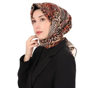 Vibrant animal print silk scarf styled as a hijab on a woman with natural makeup and black blazer. Perfect for elegant modest fashion and versatile style statements.
