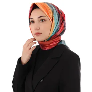 Colorful silk headscarf worn by a woman in a black blazer, showcasing Turkish fashion and cultural elegance. Perfect for stylish accessories and vibrant ethnic look.