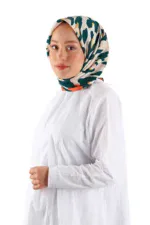 Elegant woman wearing a colorful patterned silk hijab and white dress, showcasing Turkish fashion accessories.