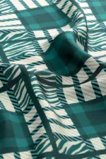 Vibrant teal and white geometric patterned fabric with stripes and zebra-like lines, showcasing a modern and stylish design perfect for fashion or home decor accents.