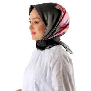 Elegant woman wearing a stylish black and floral silk hijab, showcasing modern fashion accessories from Turkey, perfect for modest fashion enthusiasts.