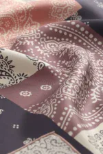 Vibrant pink, black, and white patterned bandana fabric with intricate paisley and floral designs, perfect for fashion accessories and home decor.
