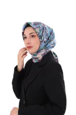 Elegant woman wearing a colorful patterned silk hijab and black blazer, showcasing modest fashion and Turkish textile craftsmanship, perfect for stylish daily wear or special occasions.