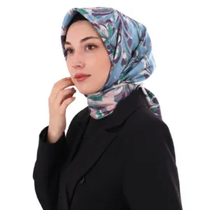 Elegant woman wearing a colorful patterned silk hijab and black blazer, showcasing modest fashion and Turkish textile craftsmanship, perfect for stylish daily wear or special occasions.