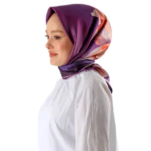 Elegant woman wearing a vibrant purple and floral silk hijab, showcasing stylish modest fashion from Turkey, perfect for modern and traditional wear.