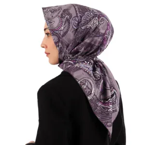 Elegant woman wearing a purple patterned silk scarf styled as a hijab, showcasing stylish modest fashion accessories for women. Perfect for daily wear or special occasions, combining comfort and sophistication.