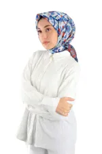 Blue floral patterned silk scarf worn by a woman with a white blouse, representing Turkish fashion and accessories. Perfect for stylish outfits, showcasing Turkish craftsmanship and vibrant designs.