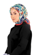 Elegant woman wearing a colorful floral silk hijab with intricate designs, paired with a black outfit, showcasing Turkish fashion and style.