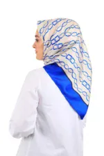 Elegant woman wearing a stylish beige and blue patterned hijab, showcasing Turkish fashion and cultural attire, available with fast shipping from Shop of Turkey.