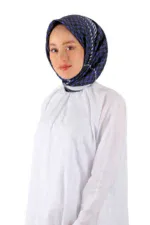 Elegant woman modeling a stylish blue patterned hijab and white modest dress, representing Turkish fashion and apparel from Shop of Turkey, with a focus on quality and modern designs.