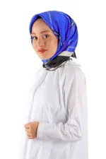 Elegant woman wearing a vibrant blue patterned silk headscarf styled in a traditional Turkish fashion, against a white background.