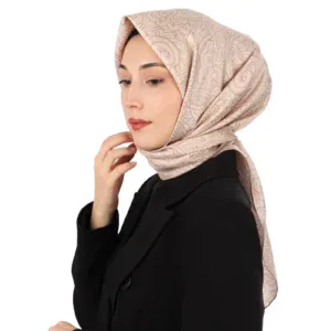 Elegant beige patterned silk hijab worn by a woman with a black blazer, showcasing modest fashion and Turkish textile craftsmanship. Perfect for stylish everyday and special occasions.