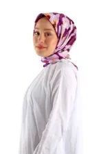 Bright woman wearing a purple, pink, and yellow camo-patterned silk headscarf and a white top, showcasing Turkish fashion and style.