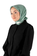 Elegant woman wearing a silky sea-green hijab and black blouse, showcasing modest fashion and cultural attire, ideal for shopping from Turkey's diverse clothing collections on Shop of Turkey.