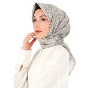 Elegant woman wearing a patterned silk scarf and white blouse, showcasing Turkish textile craftsmanship, perfect for modern fashion and cultural style.