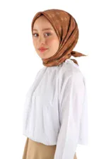 Elegant woman wearing a stylish brown silk hijab with a delicate pattern, paired with a white blouse, showcasing modest fashion from Turkey, perfect for online shopping at Shop of Turkey.