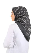 Elegant black and white patterned silk scarf worn by a woman in profile, showcasing versatile fashion accessory options for stylish outfits.